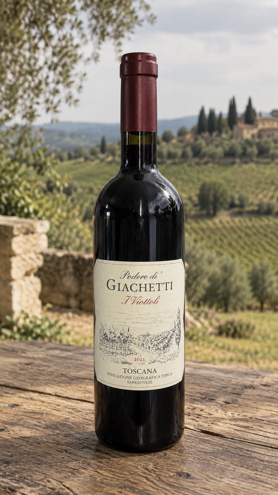 A bottle of I Viottoli on a wooden table, vineyards behind